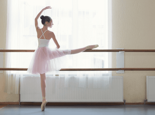 Ballerina practicing at a ballet barre
