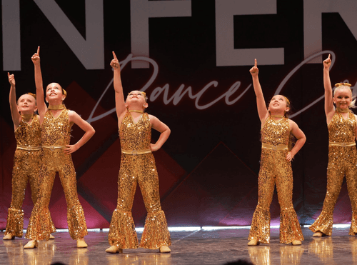 Young dancers performing in sparkling gold costumes